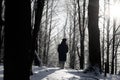 A girl stands in a winter forest on a frosty day. Blue tint