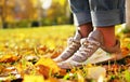 The girl stands in the yellow fallen leaves. In the autumn city park.Autumn women`s shoes on the legs of a girl. The girl is Royalty Free Stock Photo