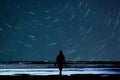 Girl stargazing at the beach the child is in silhouette looking at the night sky