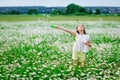 The girl starts soap bubbles in nature. A child plays in a field of daisies