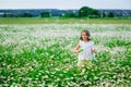 The girl starts soap bubbles in nature. A child plays in a field of daisies