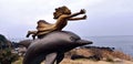 A girl statue with outstretched arms with a dolphin underneath in Jeju Island, South Korea