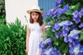 Girl staying in front of door of old stone cottage.