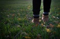 Girl steps on the grass at sunset