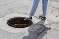 The girl steps into the open sewer hatch