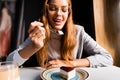 Girl sticking tongue out while eating yummy cake with coffee in cafe Royalty Free Stock Photo