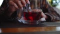 Girl stirs the red tea and puts the spoon on the plate