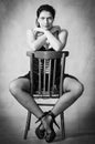 Girl in stockings sitting astride a chair