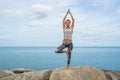 The girl on stones occupying with yoga, a drain in the Asana, yoga at the sea, on a pony of a beautiful landscape