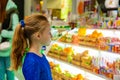 The girl in the store looks at the sweets in the window Royalty Free Stock Photo