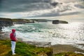 Girl at Stormy Cliffs of Kilkee in Ireland county Clare. Tourist destination Royalty Free Stock Photo