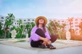A girl in a straw hat in the courtyard of a middle Eastern hotel in Tunisia. A young woman sits next to an arabic hotel amid palm Royalty Free Stock Photo