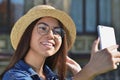 A girl in a straw hat and glasses takes a selfie