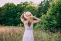 Girl in a straw hat with her back to the photographer. Girl in a white dress on a summer sunny day