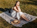 Girl with a straw hat in the spring in the park. Brunette with long hair on a background of summer nature. Youth and beauty Royalty Free Stock Photo