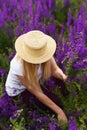 A girl in a straw hat works in the garden amongblooming flowers. Royalty Free Stock Photo