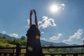 The girl stretches, looking at the morning sun and mountains. Next to her, on the railing of the balcony, is a cup of coffee Royalty Free Stock Photo