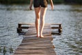 Girl strolling along a pier on pond on sunset Royalty Free Stock Photo