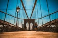 Girl strolls along the Brooklyn Bridge in New York City at sunset