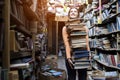 Girl student carries a large stack of books in the library, preparation for study, knowledge is power, concept Royalty Free Stock Photo