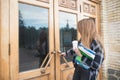 girl student in casual clothing, books and notebooks in his hands opens the door to the university Royalty Free Stock Photo