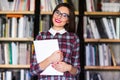 Girl student with glasses reading books in the library