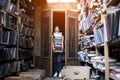 Girl student holds a large stack of books and carries a lot of literature in the library, she is preparing for study, the seller Royalty Free Stock Photo