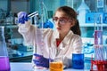 Girl student scientist mixing colored liquids with chemistry material in school science lab Royalty Free Stock Photo