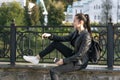 Girl student sits near the fence. Walk along the embankment