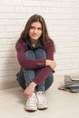 Girl sitting on the floor against a brick wall Royalty Free Stock Photo