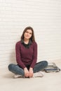 Girl sitting on the floor against a brick wall Royalty Free Stock Photo