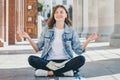 Girl student sitting on the floor and meditating. Lovely girl asks for a good grade in the exam