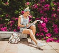 Girl student sitting in summer park and doing homework. Modern style of the girl. Model with tattoos Royalty Free Stock Photo