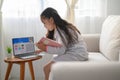 Girl student sitting at the table, writing homework . Teen using laptop computer to study.New normal.Social distancing.stay home