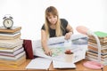 Girl student studying design drawing master plan at table cluttered with books