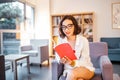 Girl student with stylish glasses reading books in the library Royalty Free Stock Photo