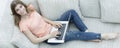 Girl student working with laptop sitting on sofa and looking at camera. Royalty Free Stock Photo