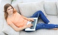 Girl student working with laptop sitting on sofa and looking at camera. Royalty Free Stock Photo