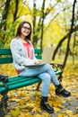 Girl students working on laptop in autumn park Royalty Free Stock Photo