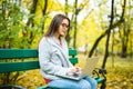 Girl students working on laptop in autumn park Royalty Free Stock Photo