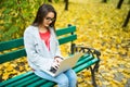 Girl students working on laptop in autumn park Royalty Free Stock Photo