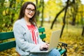 Girl students working on laptop in autumn park Royalty Free Stock Photo