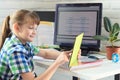 A girl is studying at home, watching a remote lesson on a tablet