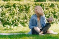 Girl in a stylish ijak holds a folder. The concept of onlay work freelancer outdoors in a big city in the park in the summer