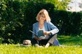 Girl in a stylish ijak holds a folder. The concept of onlay work freelancer outdoors in a big city in the park in the summer