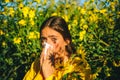 The girl suffers from pollen allergy during flowering and uses napkins. Beautiful young woman lies on flowers