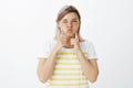 Girl suggest not to sulk but enjoy life. Portrait of carefree happy beautiful woman in striped t-shirt, pouting and