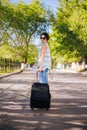 Girl with a suitcase. Model holds a cell phone in his hands. Waiting for a trip