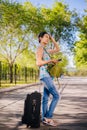 Girl with a suitcase. Model holds a cell phone in his hands. Waiting for a trip