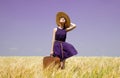 Girl with suitcase at spring wheat field. Royalty Free Stock Photo
